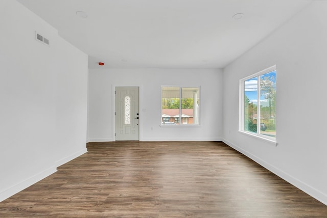 interior space with visible vents, baseboards, and wood finished floors