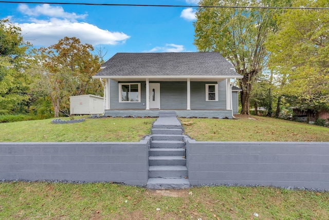 bungalow-style home with a front yard, a porch, and a shingled roof