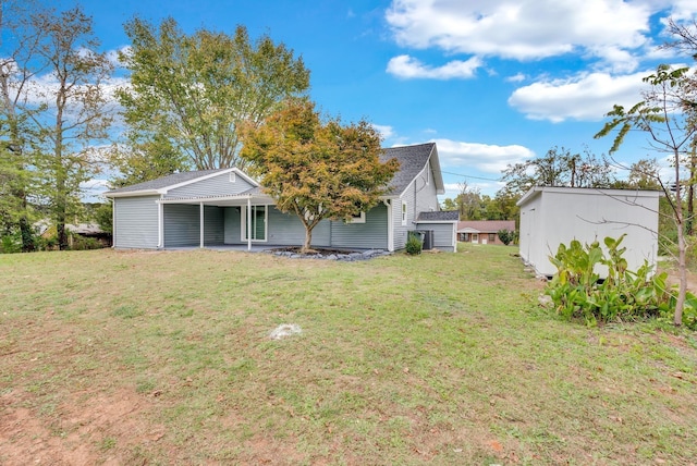 exterior space featuring an attached carport, a yard, and an outbuilding