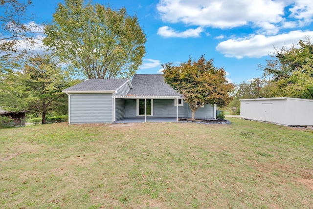 view of front of house featuring a patio, a shingled roof, and a front lawn