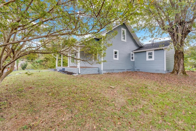 exterior space with a yard, crawl space, and a shingled roof