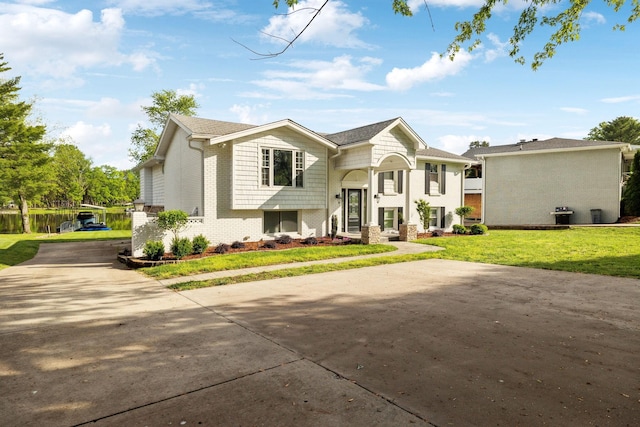 1048 Edgewater Cir, Gallatin, TN 37066 - split foyer home featuring a front lawn, concrete driveway, and brick siding
