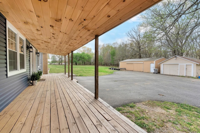 wooden deck with a yard, an outdoor structure, and a detached garage
