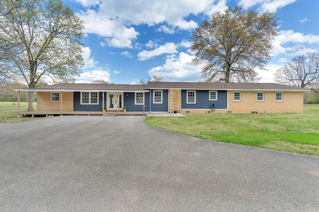 single story home featuring a front yard, covered porch, and aphalt driveway