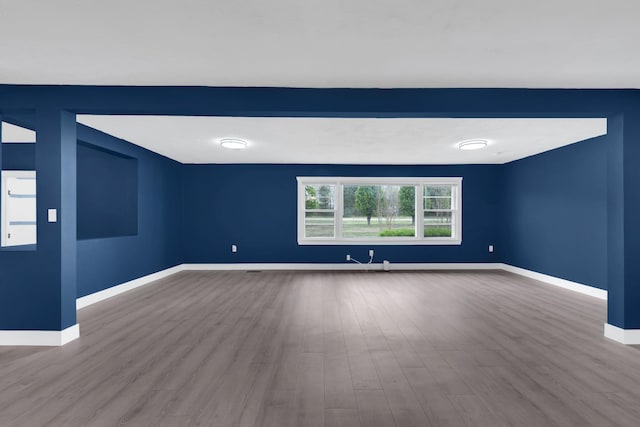 empty room featuring baseboards and wood finished floors