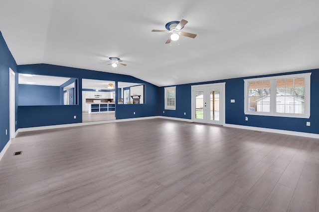 unfurnished living room featuring ceiling fan, wood finished floors, vaulted ceiling, and baseboards