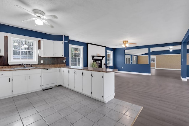 kitchen featuring ceiling fan, white cabinetry, dishwasher, a sink, and open floor plan