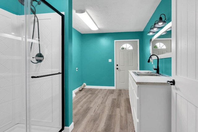 laundry room featuring baseboards, light wood-type flooring, and a sink