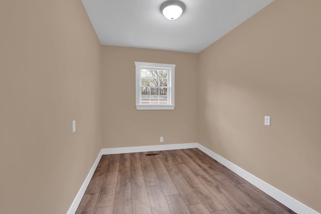 empty room featuring baseboards and wood finished floors