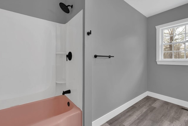 full bathroom featuring shower / bath combination, wood finished floors, and baseboards