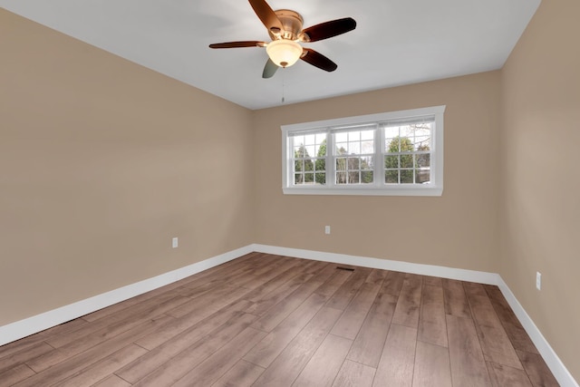 spare room featuring visible vents, ceiling fan, wood finished floors, and baseboards