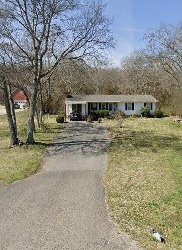 view of front of property featuring driveway and a front yard