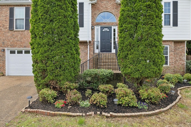 property entrance featuring brick siding and driveway