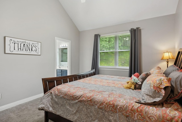 bedroom featuring carpet flooring, baseboards, vaulted ceiling, and ensuite bath