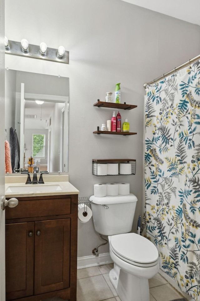 bathroom featuring baseboards, a shower with shower curtain, toilet, vanity, and tile patterned flooring