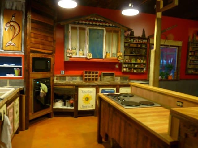 kitchen with wood counters, open shelves, a sink, and black appliances