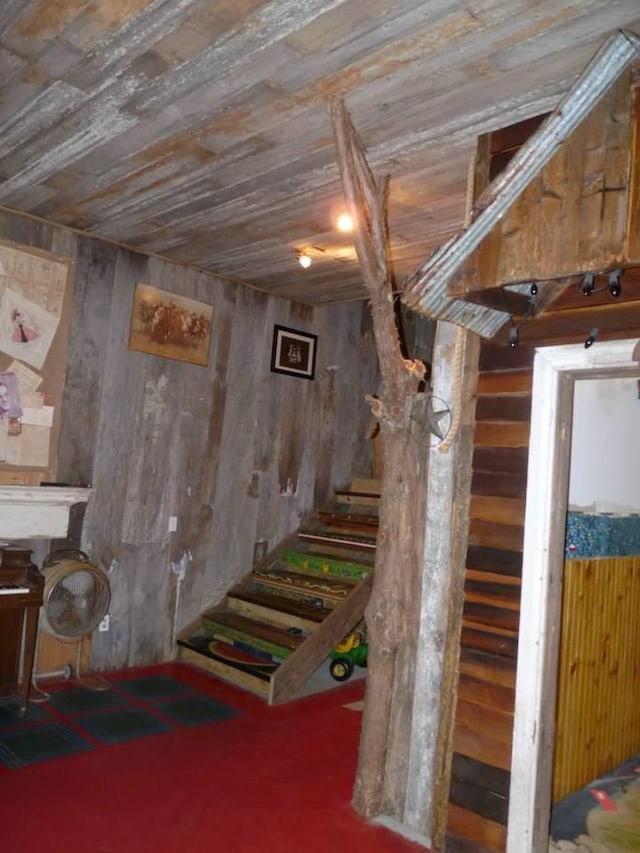 below grade area with wooden walls, wood ceiling, and stairs