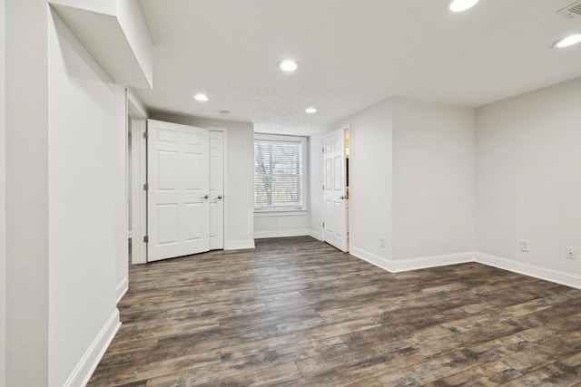 spare room featuring baseboards, dark wood-style floors, visible vents, and recessed lighting