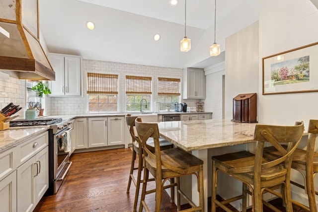 210 Cherokee Rd, Nashville, TN 37205 - kitchen with tasteful backsplash, a breakfast bar, under cabinet range hood, stainless steel appliances, and light stone counters