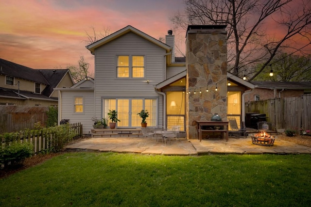 210 Cherokee Rd, Nashville, TN 37205 - back of property at dusk featuring an outdoor fire pit, a patio, a lawn, and a chimney
