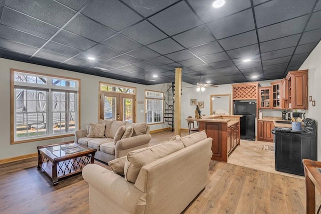 700 Falls Rd, Monterey, TN 38574 - living room with light wood-style flooring, a paneled ceiling, baseboards, and stairs