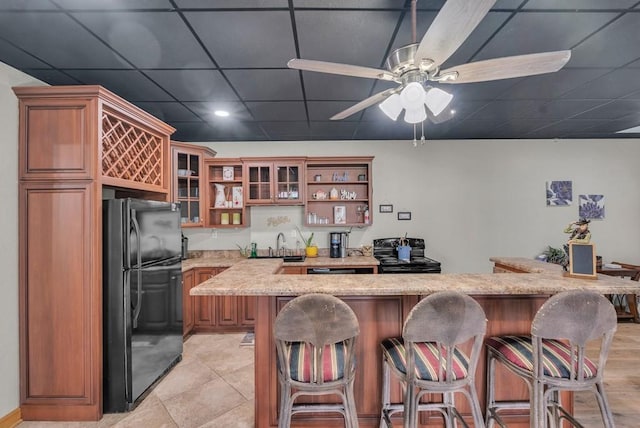 700 Falls Rd, Monterey, TN 38574 - kitchen with open shelves, a sink, a kitchen breakfast bar, brown cabinets, and black appliances