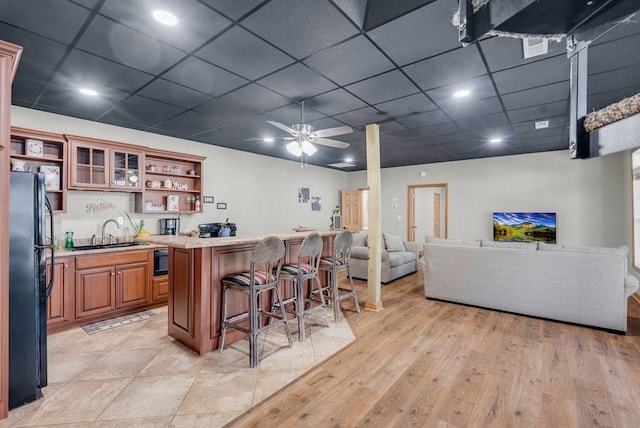 700 Falls Rd, Monterey, TN 38574 - kitchen featuring open shelves, a sink, freestanding refrigerator, a kitchen bar, and brown cabinetry