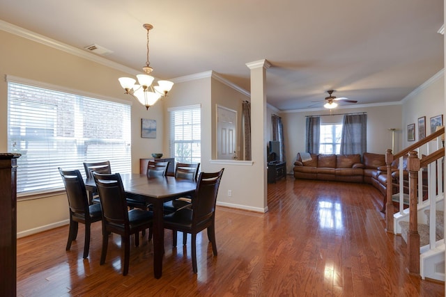dining room with visible vents, ceiling fan with notable chandelier, crown molding, and wood finished floors
