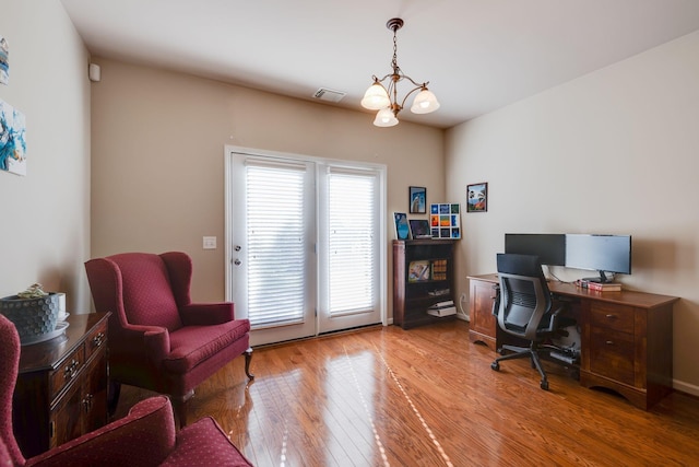home office featuring light wood-type flooring, an inviting chandelier, baseboards, and visible vents