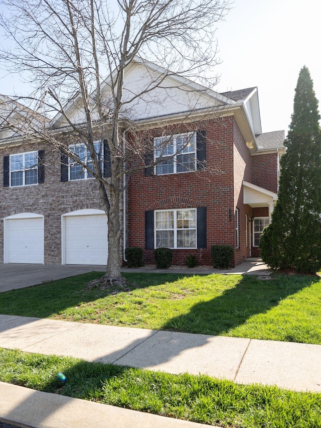 view of front of property with brick siding, a front lawn, an attached garage, and driveway