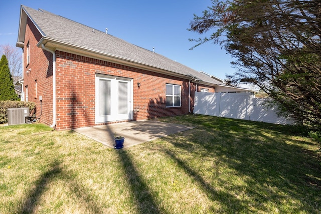 rear view of property with a patio area, a yard, cooling unit, and fence