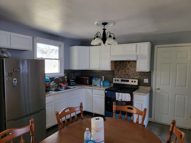 kitchen with freestanding refrigerator, white cabinetry, a sink, range with electric cooktop, and a notable chandelier