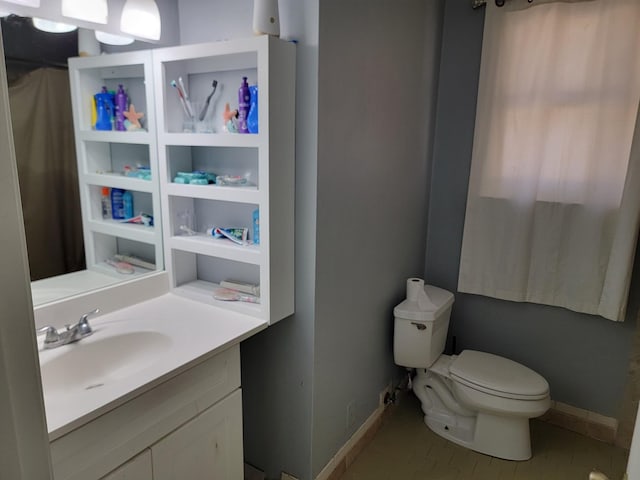bathroom featuring vanity, baseboards, and toilet