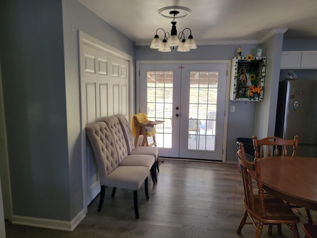 dining room with french doors, an inviting chandelier, baseboards, and wood finished floors