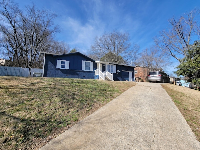 ranch-style home featuring an attached garage, driveway, a front yard, and fence
