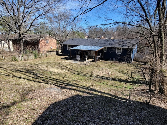 back of property featuring a yard and fence