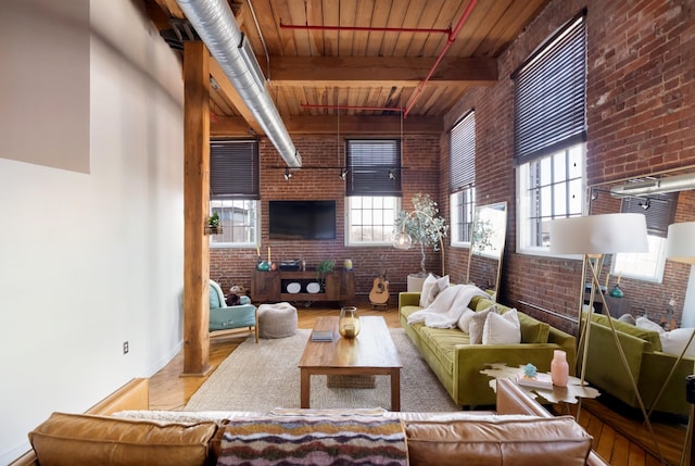 1400 Rosa L Parks Blvd Unit 318, Nashville, TN 37208 - living room with beamed ceiling, wood finished floors, brick wall, and a healthy amount of sunlight