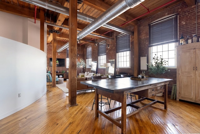 1400 Rosa L Parks Blvd Unit 318, Nashville, TN 37208 - dining room with light wood-style floors, a towering ceiling, wood ceiling, brick wall, and beam ceiling