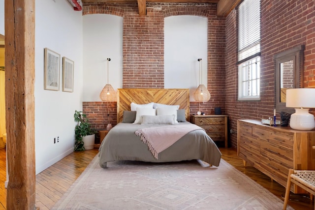 1400 Rosa L Parks Blvd Unit 318, Nashville, TN 37208 - bedroom with brick wall, light wood-style flooring, a high ceiling, and baseboards