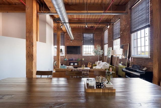 1400 Rosa L Parks Blvd Unit 318, Nashville, TN 37208 - unfurnished living room featuring track lighting, brick wall, beam ceiling, and wooden ceiling
