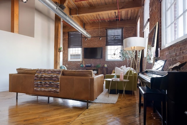 1400 Rosa L Parks Blvd Unit 318, Nashville, TN 37208 - living room featuring beamed ceiling, hardwood / wood-style floors, a high ceiling, wood ceiling, and brick wall