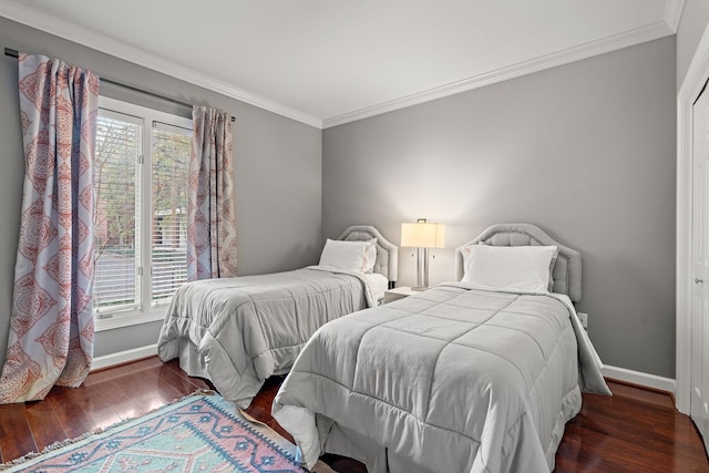 bedroom with ornamental molding, baseboards, and wood finished floors