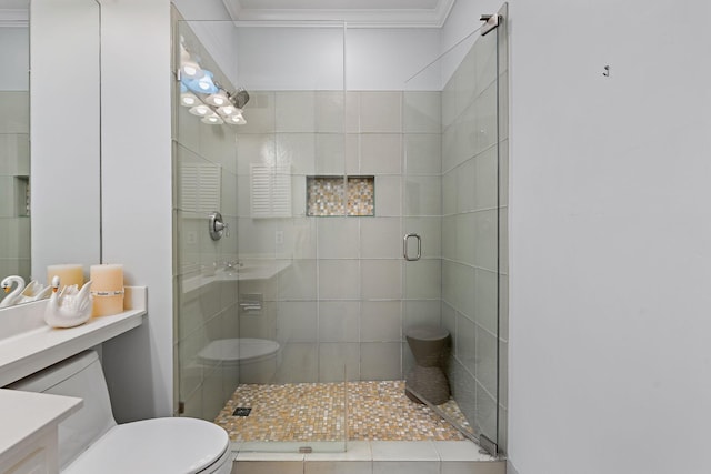 bathroom featuring ornamental molding, toilet, a shower stall, and vanity