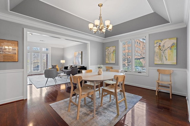 dining room with a raised ceiling, crown molding, a notable chandelier, and dark wood-style floors