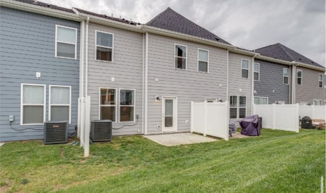 rear view of house with fence, a lawn, central AC, and a patio area