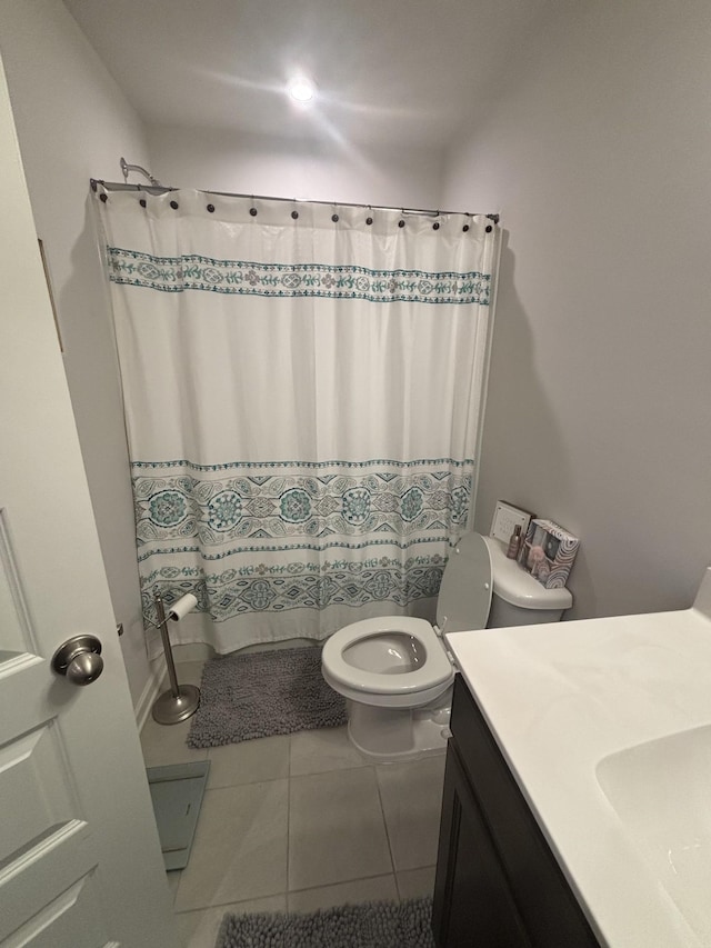 full bathroom with a shower with curtain, tile patterned floors, vanity, and toilet