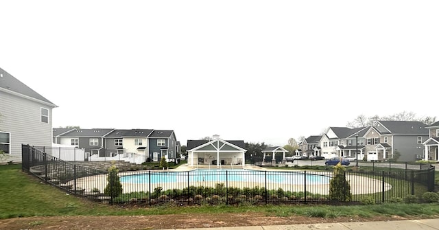 community pool featuring a residential view and fence