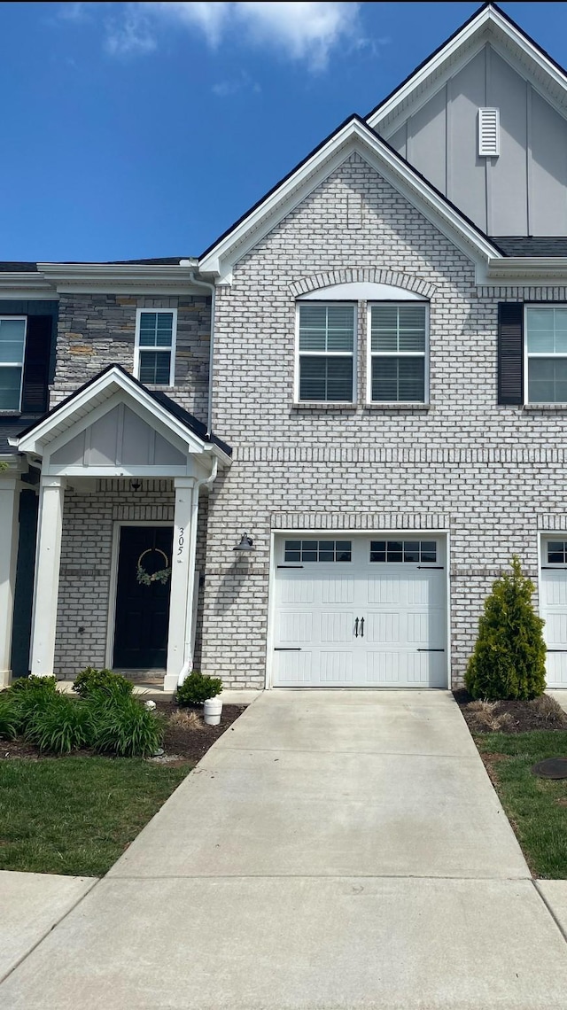 view of front facade featuring a garage, driveway, and brick siding