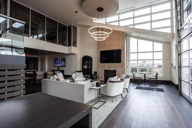 600 12th Ave S Unit 521, Nashville, TN 37203 - living area with a notable chandelier, a tile fireplace, a towering ceiling, and wood finished floors