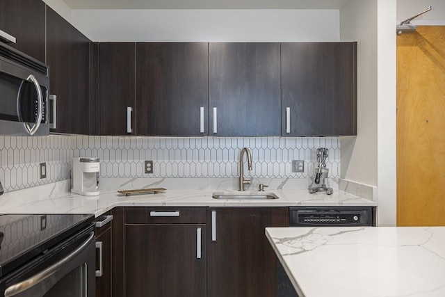 600 12th Ave S Unit 521, Nashville, TN 37203 - kitchen with stainless steel microwave, light stone counters, electric range, decorative backsplash, and a sink